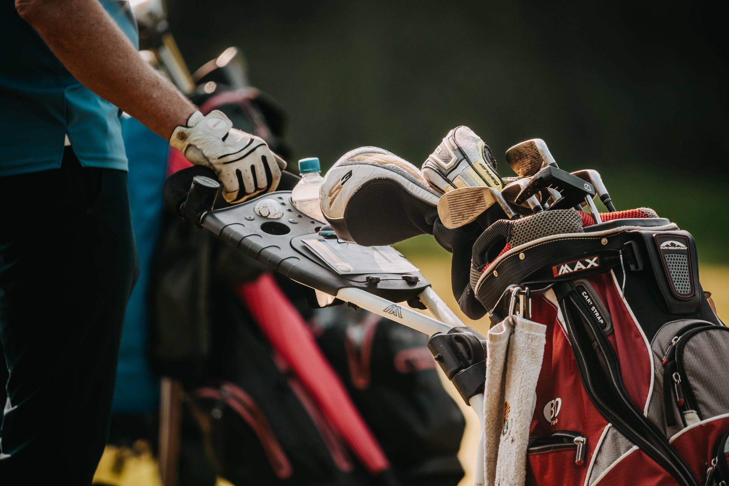 Golfbags und Golfschläger auf einem Trolley, unterwegs zum Golfplatz